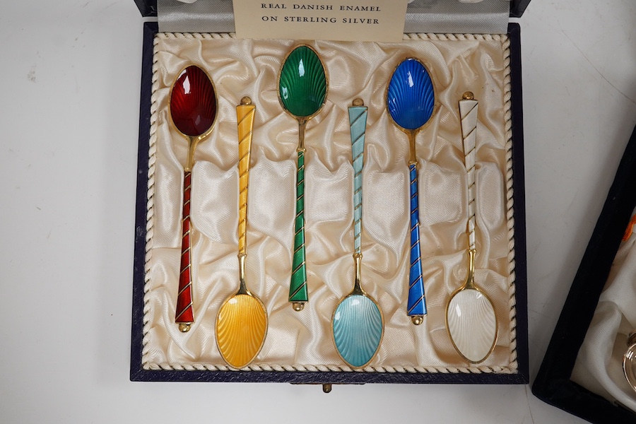 A mid 20th century cased set of six Danish gilt sterling and polychrome enamel coffee spoons, by Egon Lauridson, 94mm, together with one other set of six white metal and enamelled teaspoons, stamped 'silver'. Condition -